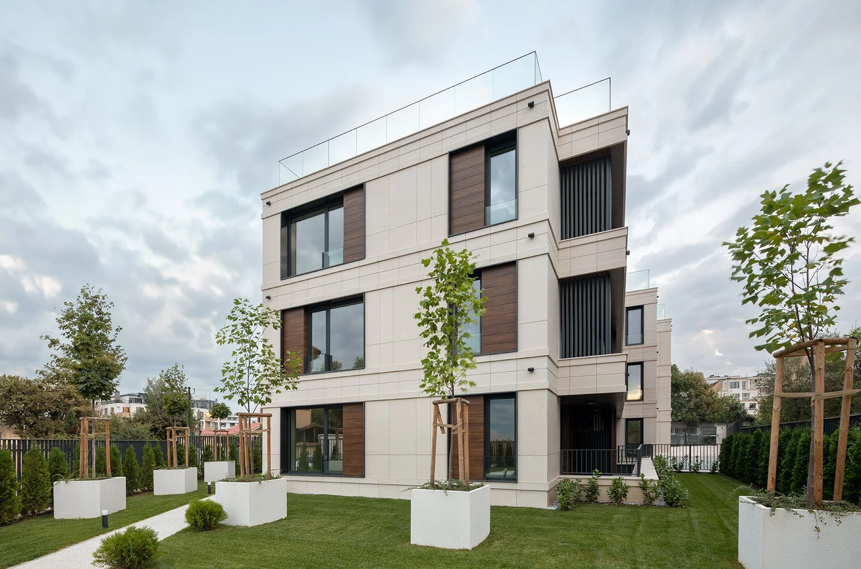 Sunset Garden residential building in Sofia with stone facade, balconies, and landscaped garden