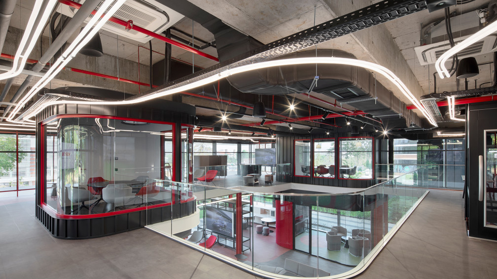Офис интериор в индустриален стил, проектиран от ИПА Архитекти, с двуетажно open space пространство и червени метални акценти