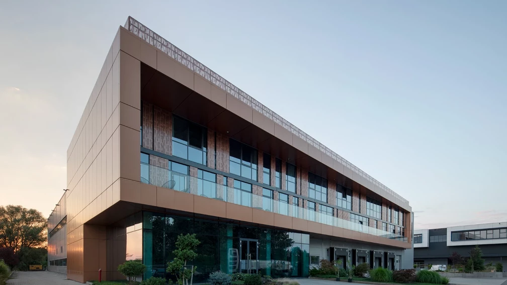 SEG Work & Logistic Hub in Krivina with a glazed office facade and copper-colored cladding panels