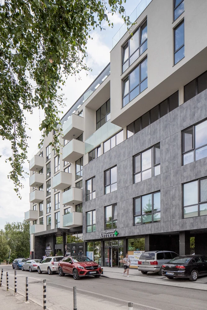 Фасада на Adella Residence с каменна облицовка и жилищни балкони