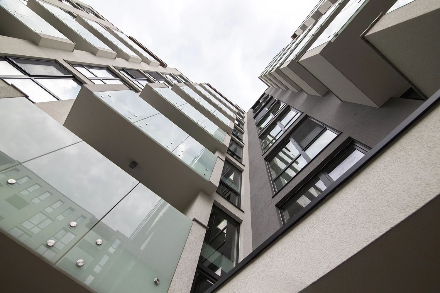 Поглед нагоре между фасадите във вътрешното пространство на Adella Residence