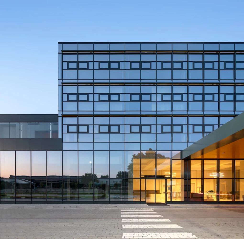Detail of the glazed facade and illuminated entrance of the AREON administrative building