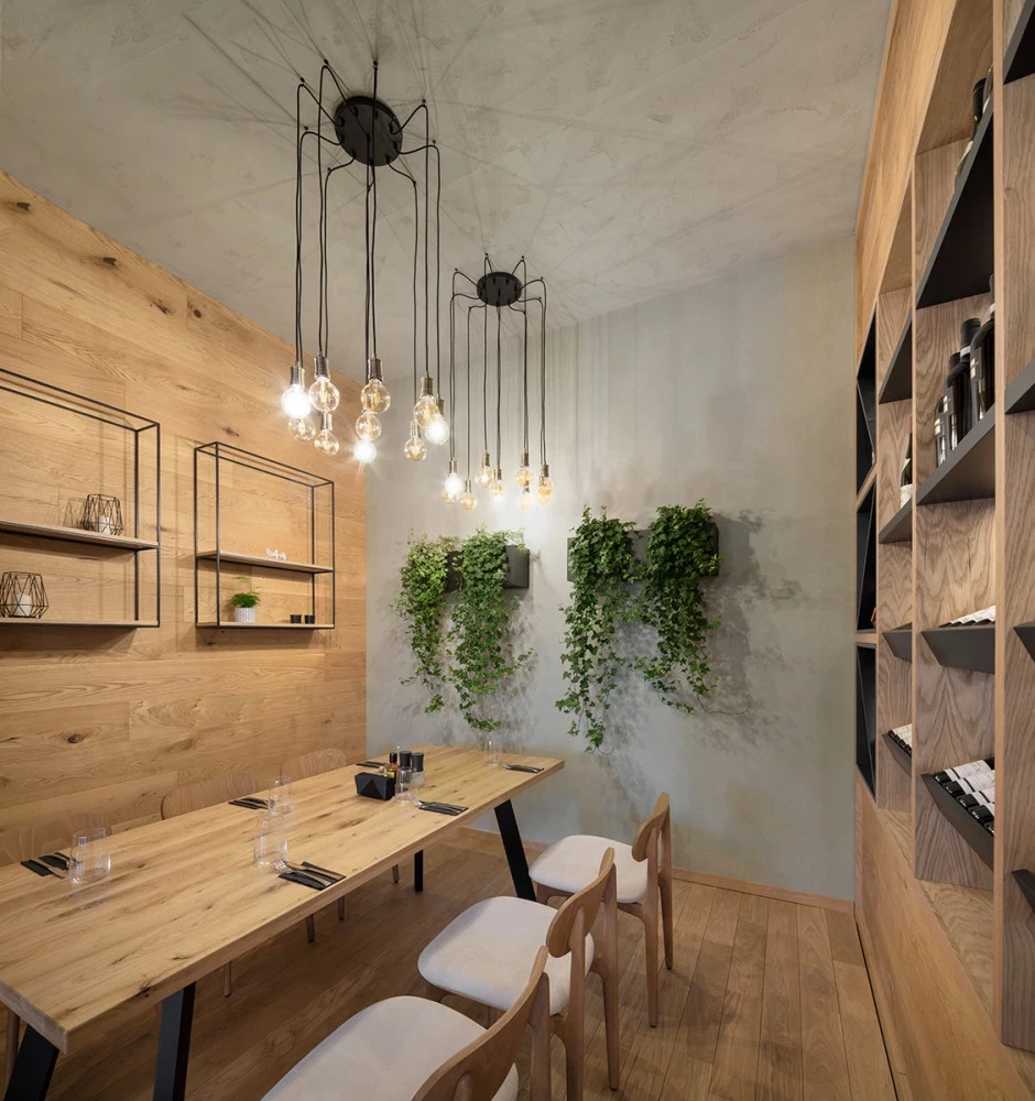Dining area at Bella Vista with wood furniture, pendant lighting, and greenery