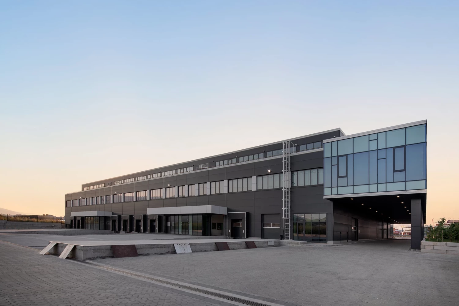 Administrative facade of BG Line Logistics Base with colonnade and glazed office spaces