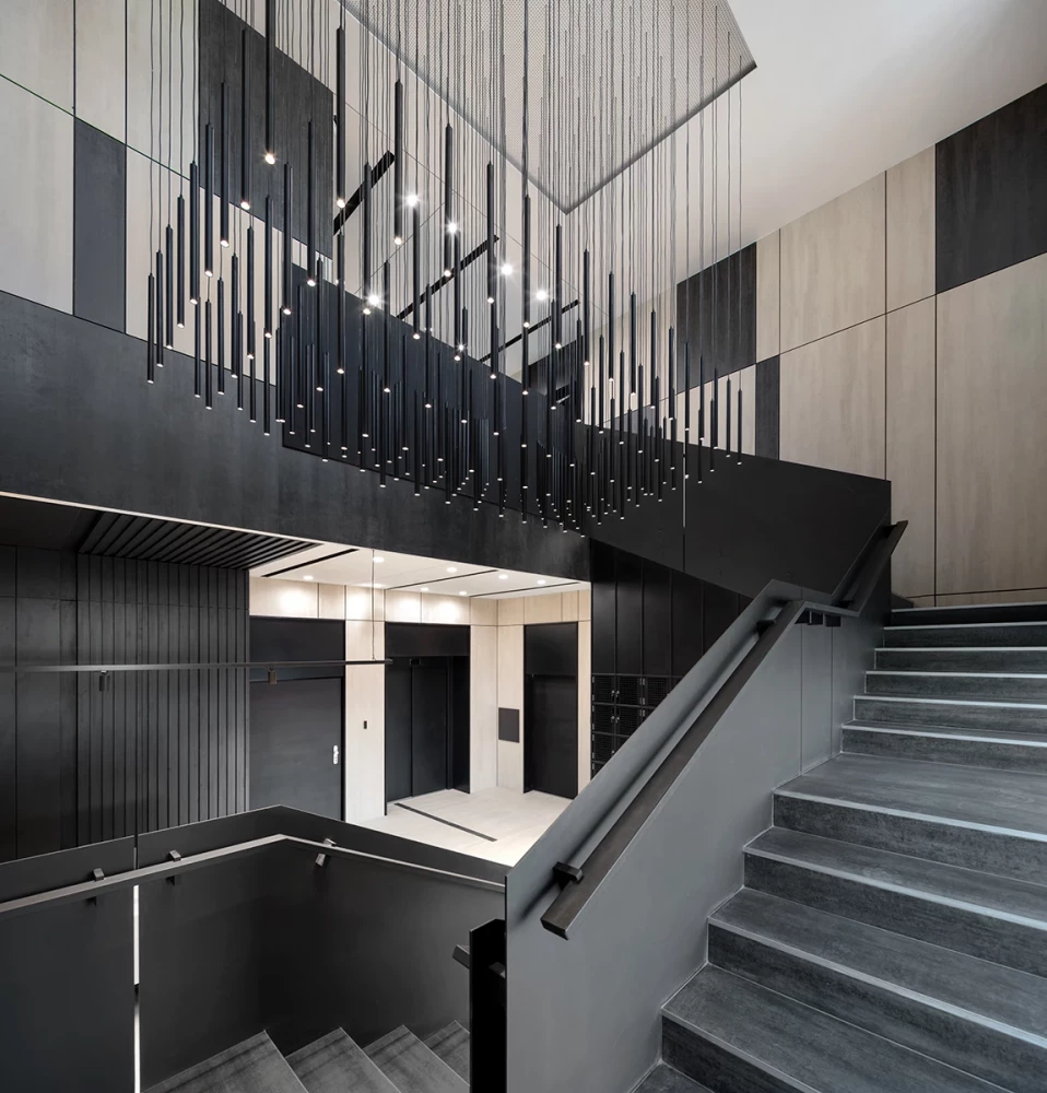 Staircase in the CSC lobby with dark finishes and suspended decorative installation