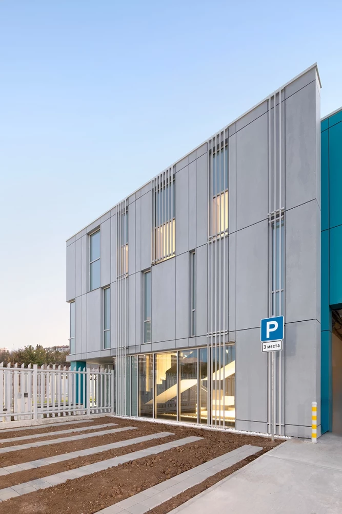 Side view of the CSC building in Pleven with glazed ground floor and parking area