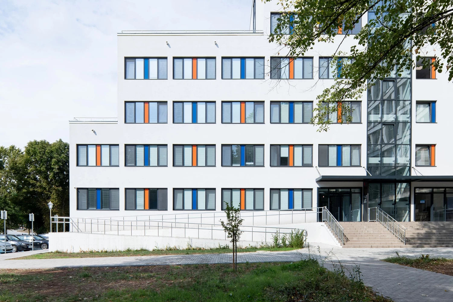 Main facade of the new hospital wing with entrance area and colored window frames