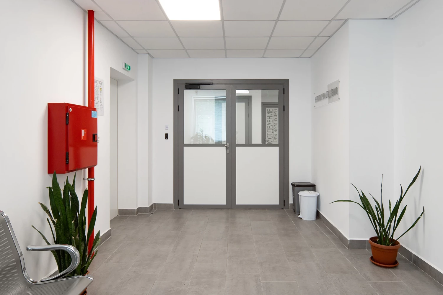 Interior corridor in the new hospital wing with fire safety equipment and double doors