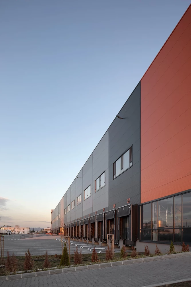 Architectural facade detail of the Fresh&Frozen facility with orange and gray panels