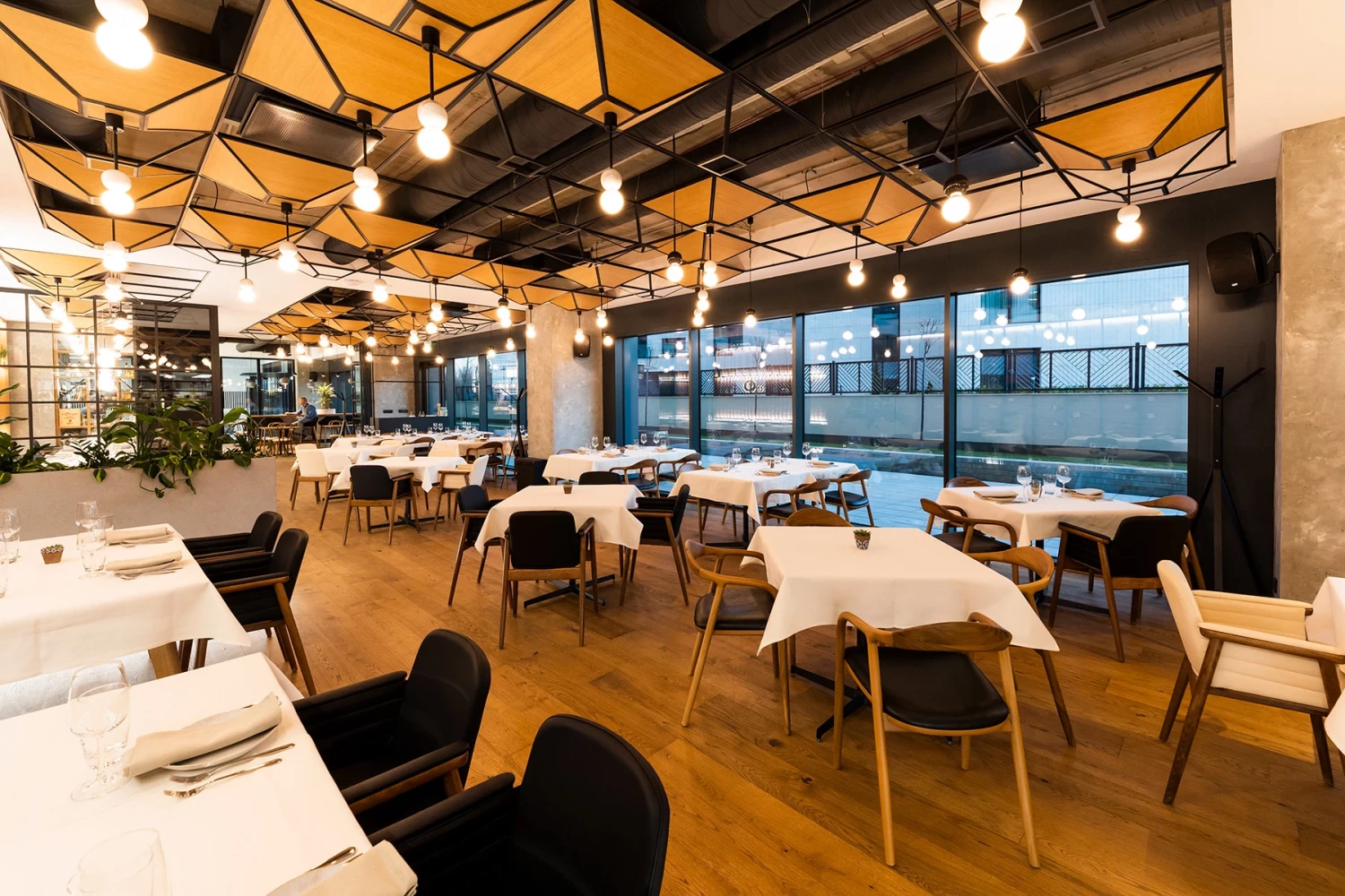 Main dining room at GORA Restaurant with varied seating areas and floor-to-ceiling windows