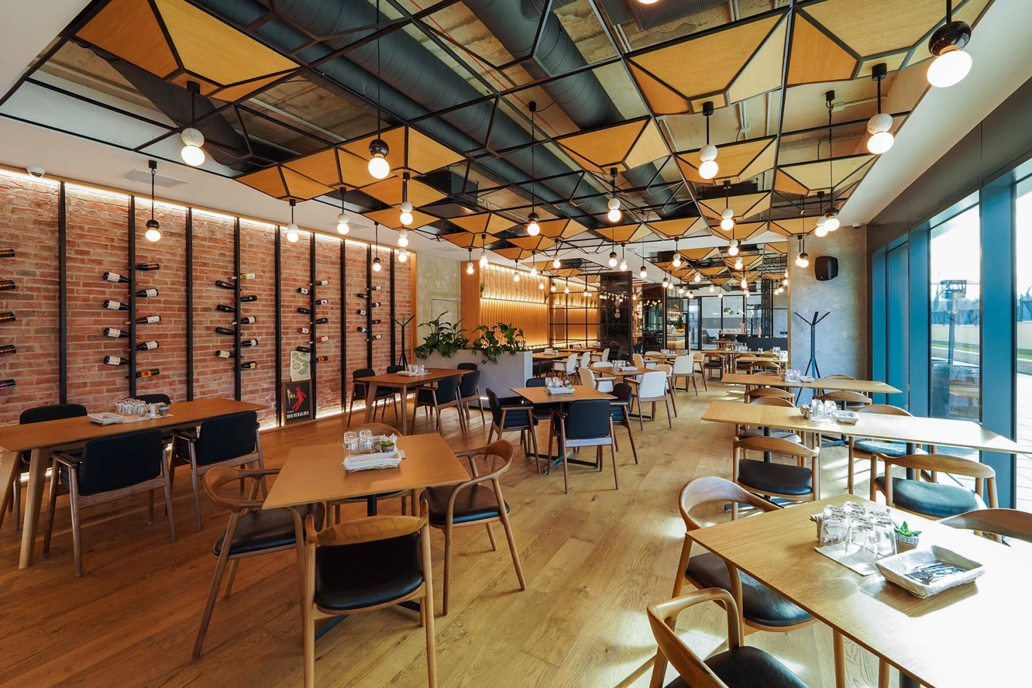 Dining area at GORA Restaurant with wood furniture and decorative wall treatment