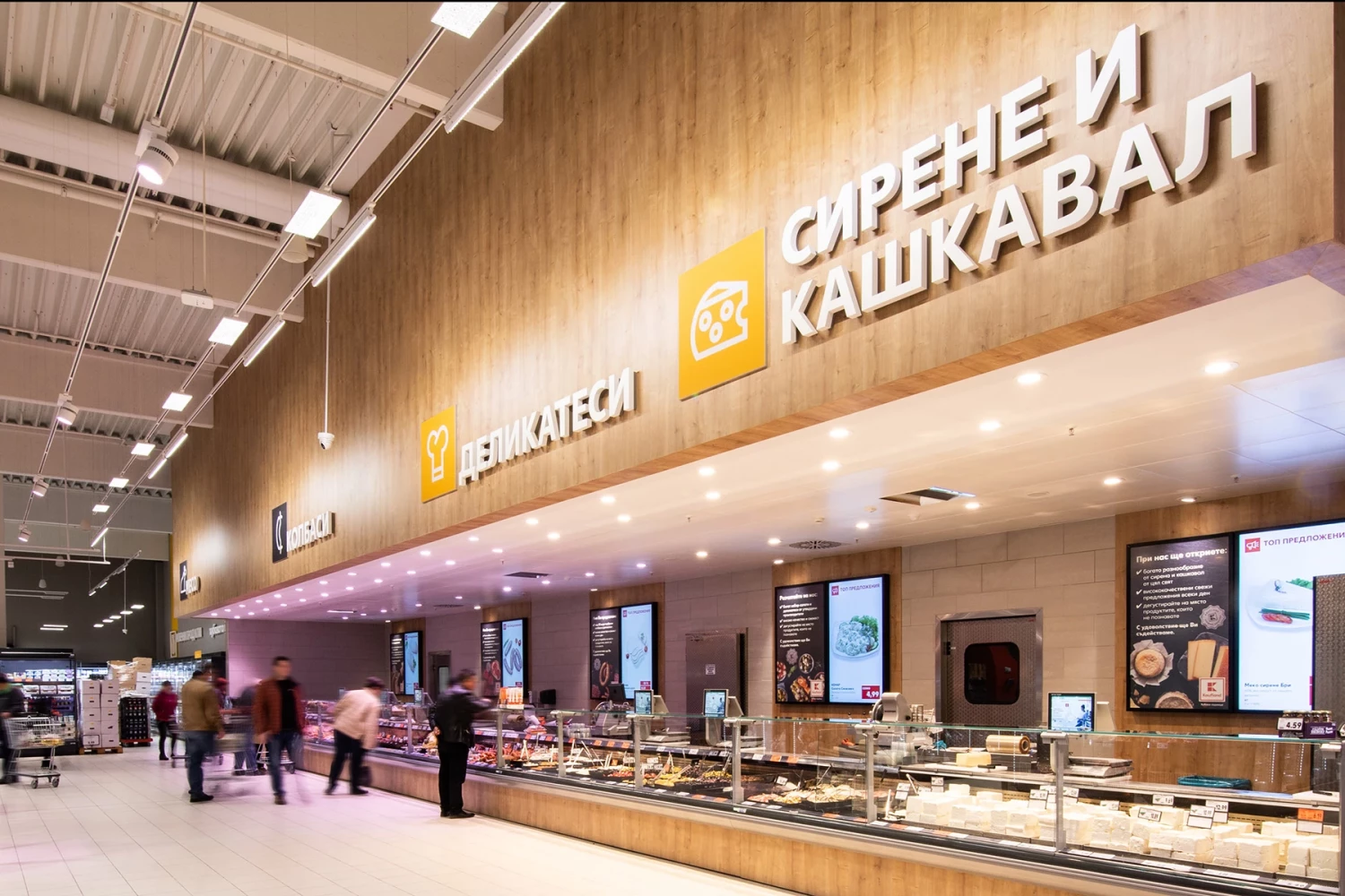 Зона с обслужващи щандове и осветена навигация в супермаркет Kaufland
