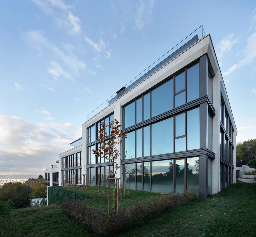 Ъглов изглед към M Residence с остъклена фасада и естествено озеленяване