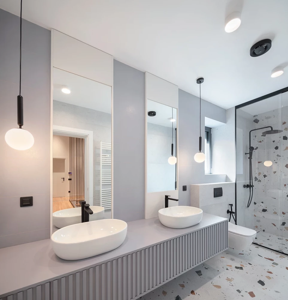 Bathroom in the SPV house with double sinks, pendant lights, and a walk-in shower