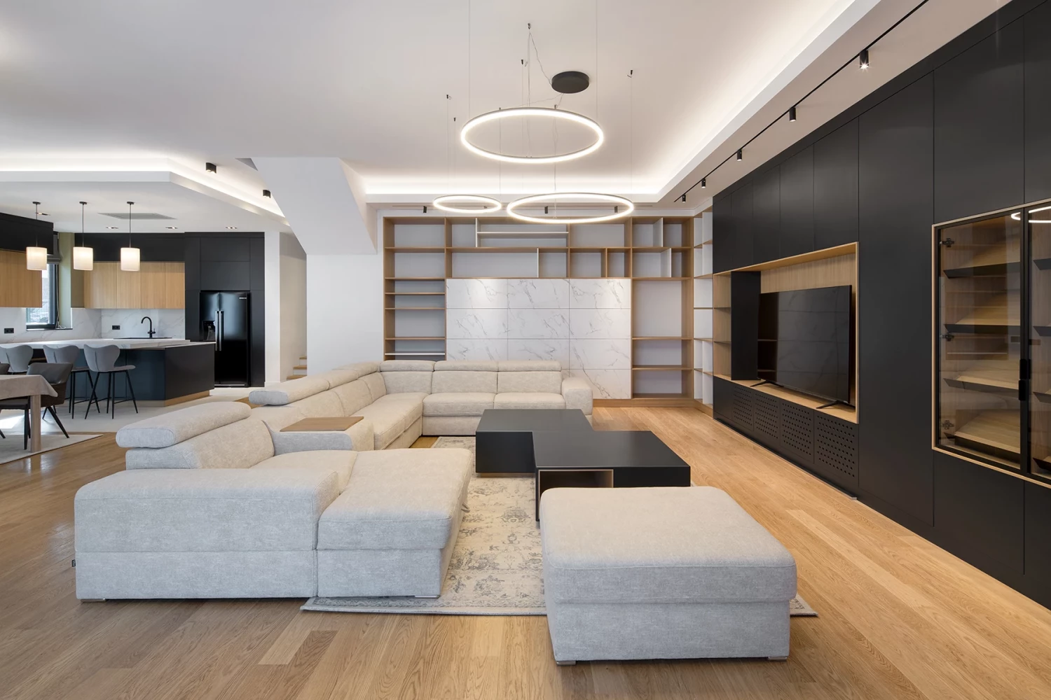 Open-plan living area in the SPV house with upholstered furniture and wood accents