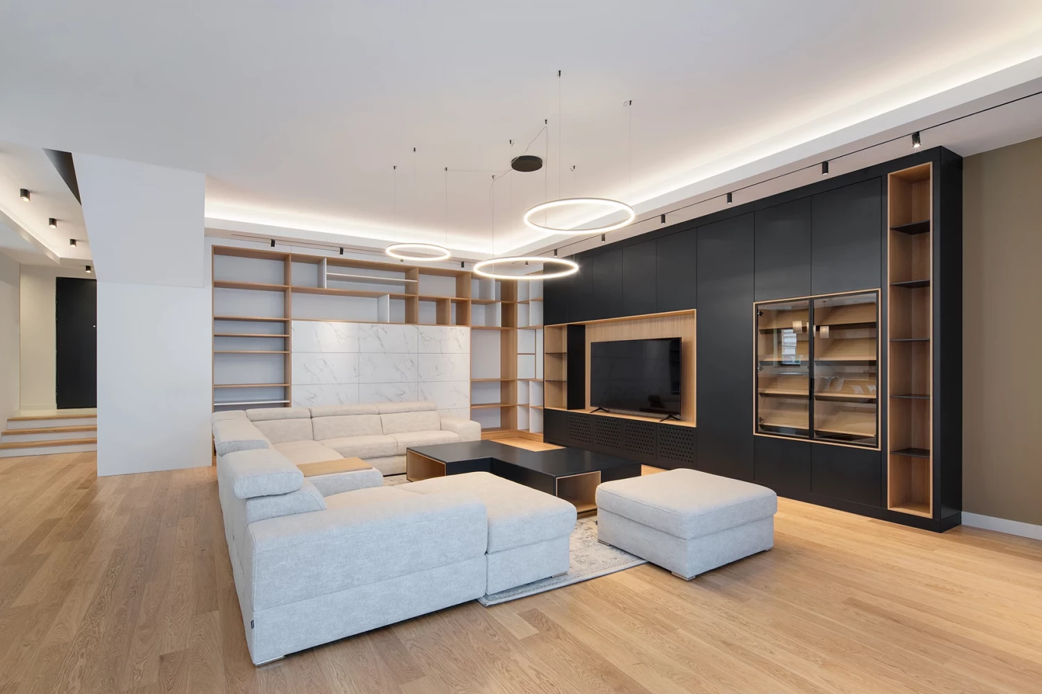 SPV house living room interior with fireplace, shelving, and light wood flooring