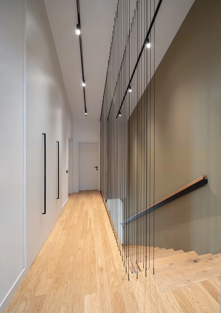 Second-floor corridor in the SPV house with wood flooring and a minimalist interior