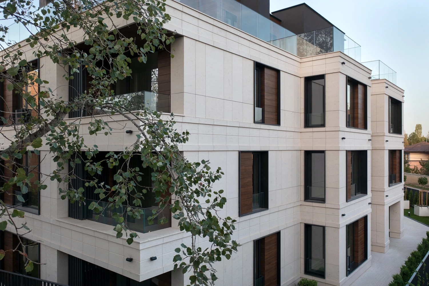 Sunset Garden facade detail with stone panels, windows, and balconies