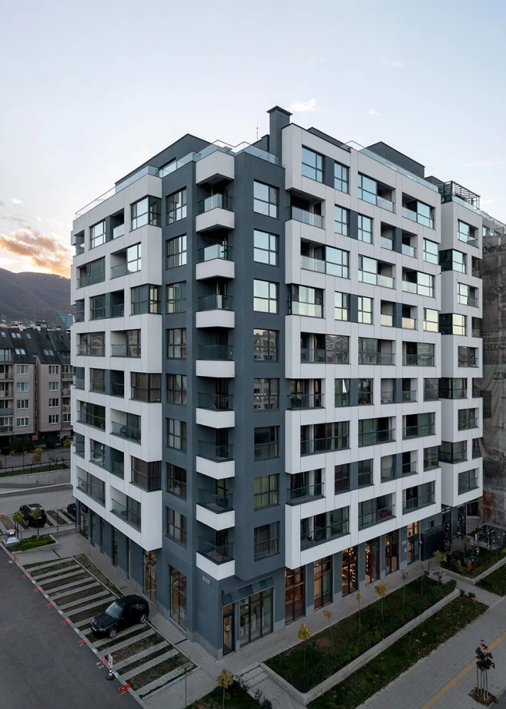 Corner view of Veda Resort with balconies and ground-floor commercial spaces