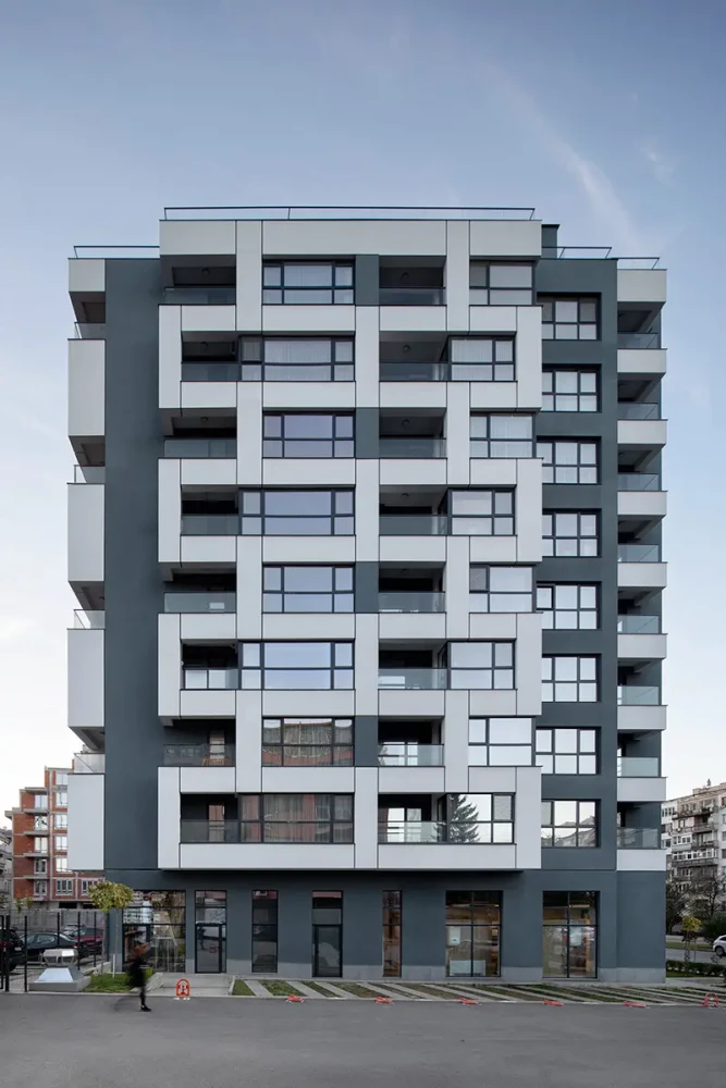 Front facade of Veda Resort with glazing, balconies, and a dark central accent