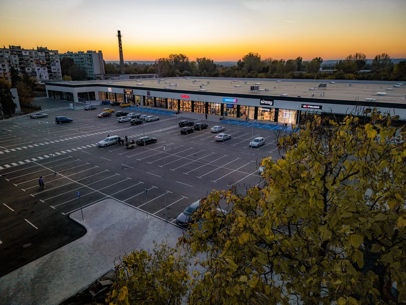 Vidin Plaza Retail Park at sunset with parking and a row of retail units