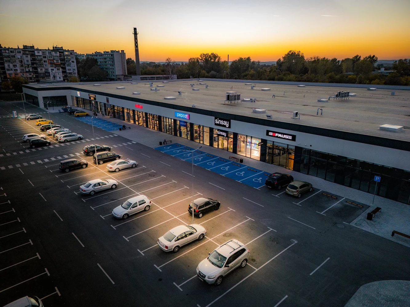 Retail facade and parking area at Vidin Plaza in the evening
