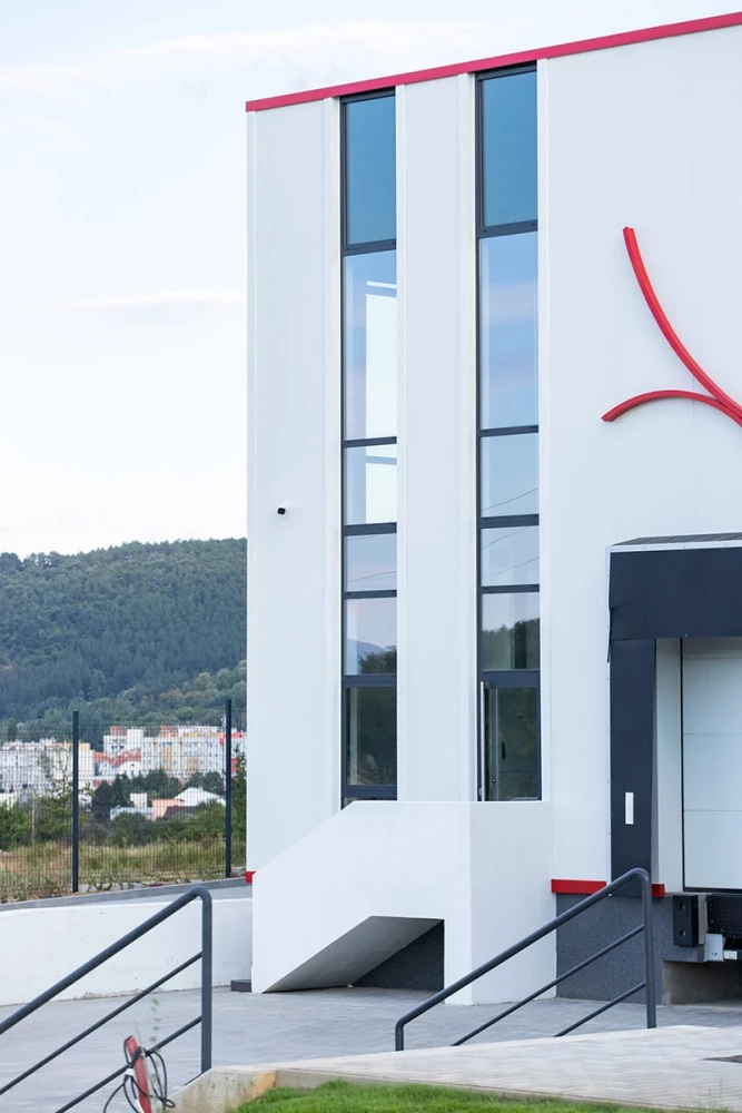 Facade detail with vertical glazing at the VolaPlast production facility by IPA - Architecture and more