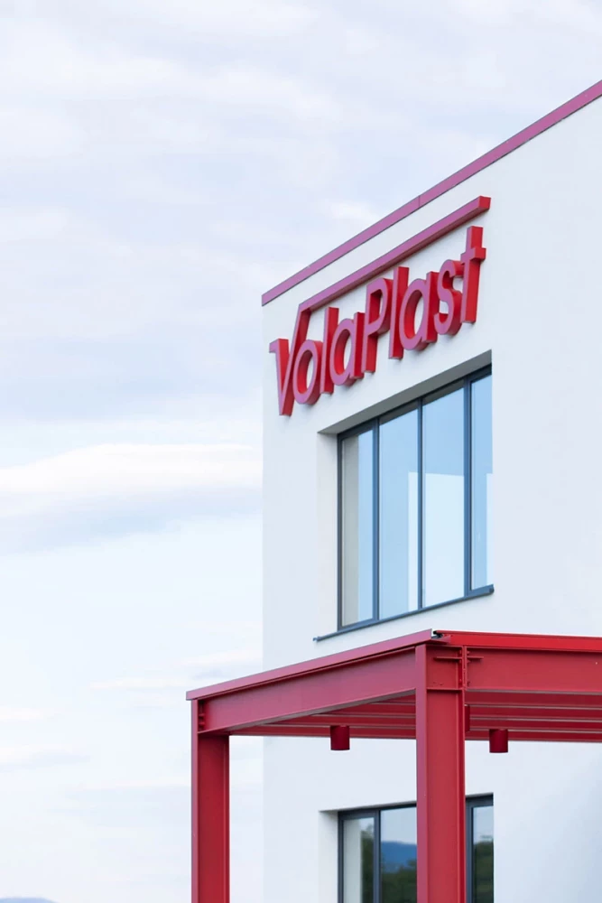 Administrative facade detail of VolaPlast with company signage and a red entrance canopy