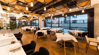 General view of GORA Restaurant interior with varied seating areas and an exposed ceiling