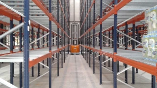 Warehouse interior with high-bay racking systems and a central aisle