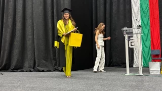 UACEG graduate on stage with a certificate and presentation gift