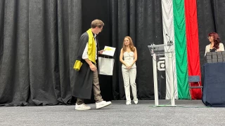 UACEG graduate leaving the stage with a certificate and presentation gift